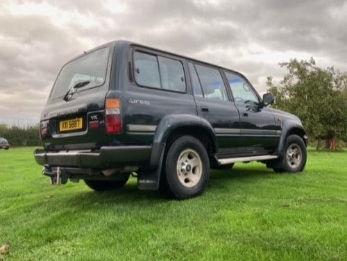 Back corner view of green Toyota Land Cruiser