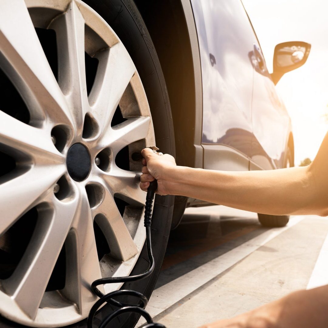 Inflating a car tyre using a pump to help minimise pothole damage.